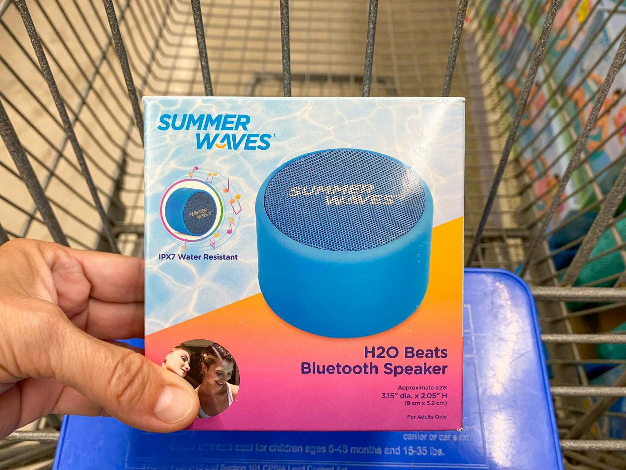 hand holding summer waves bluetooth speaker on walmart cart
