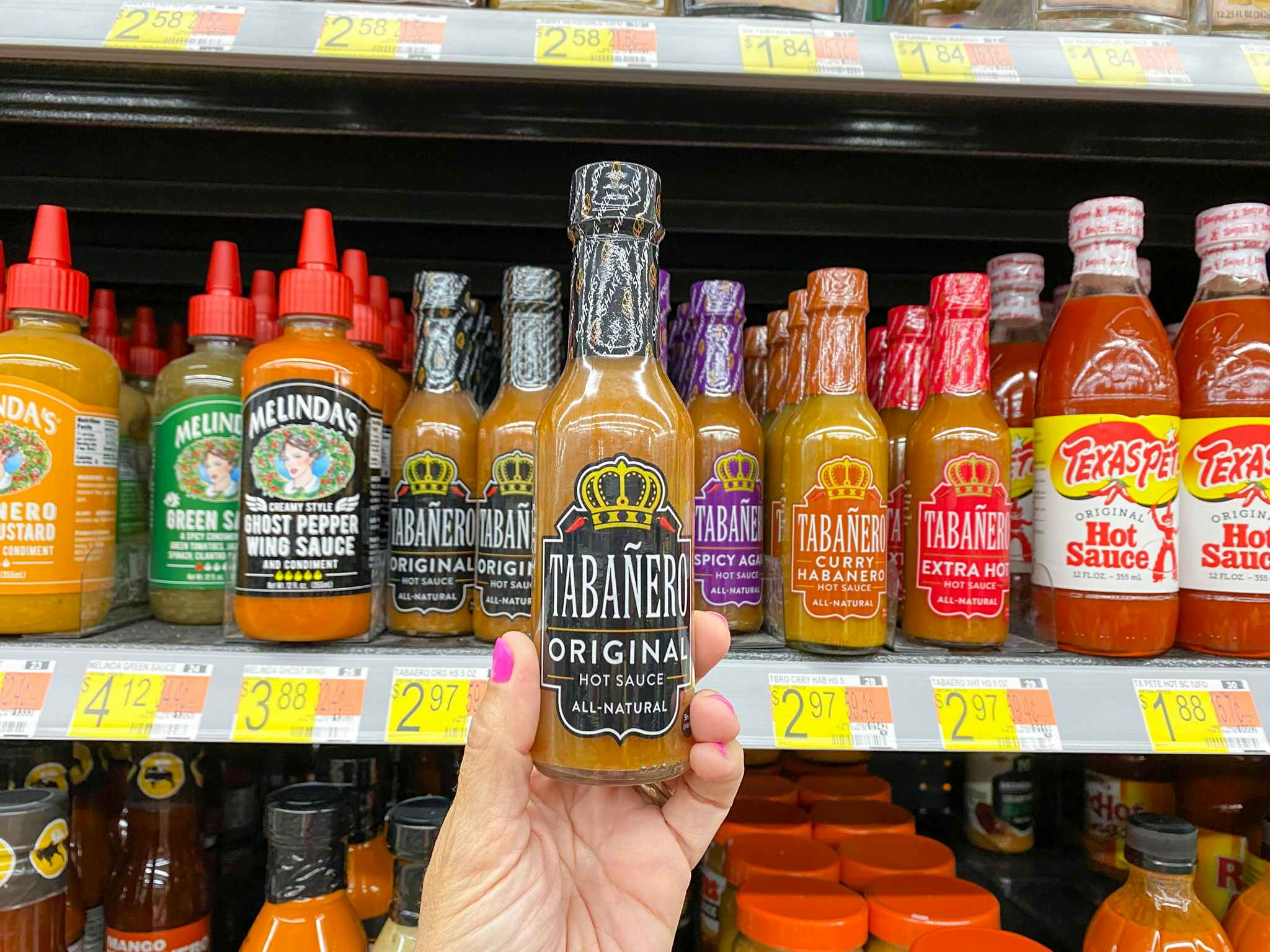 hand holding tabanero hot sauce at walmart