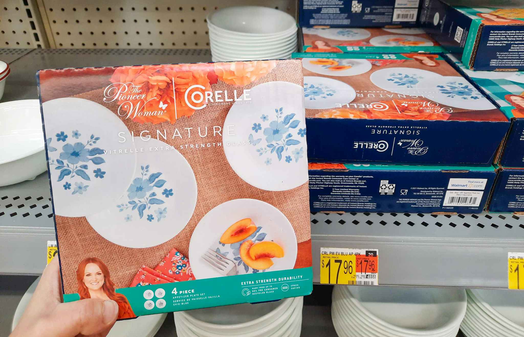 The Pioneer Woman by Corelle 4-Piece Appetizer Plate Set held in front of display at Walmart. Price tag indicates that the price is $17.96.