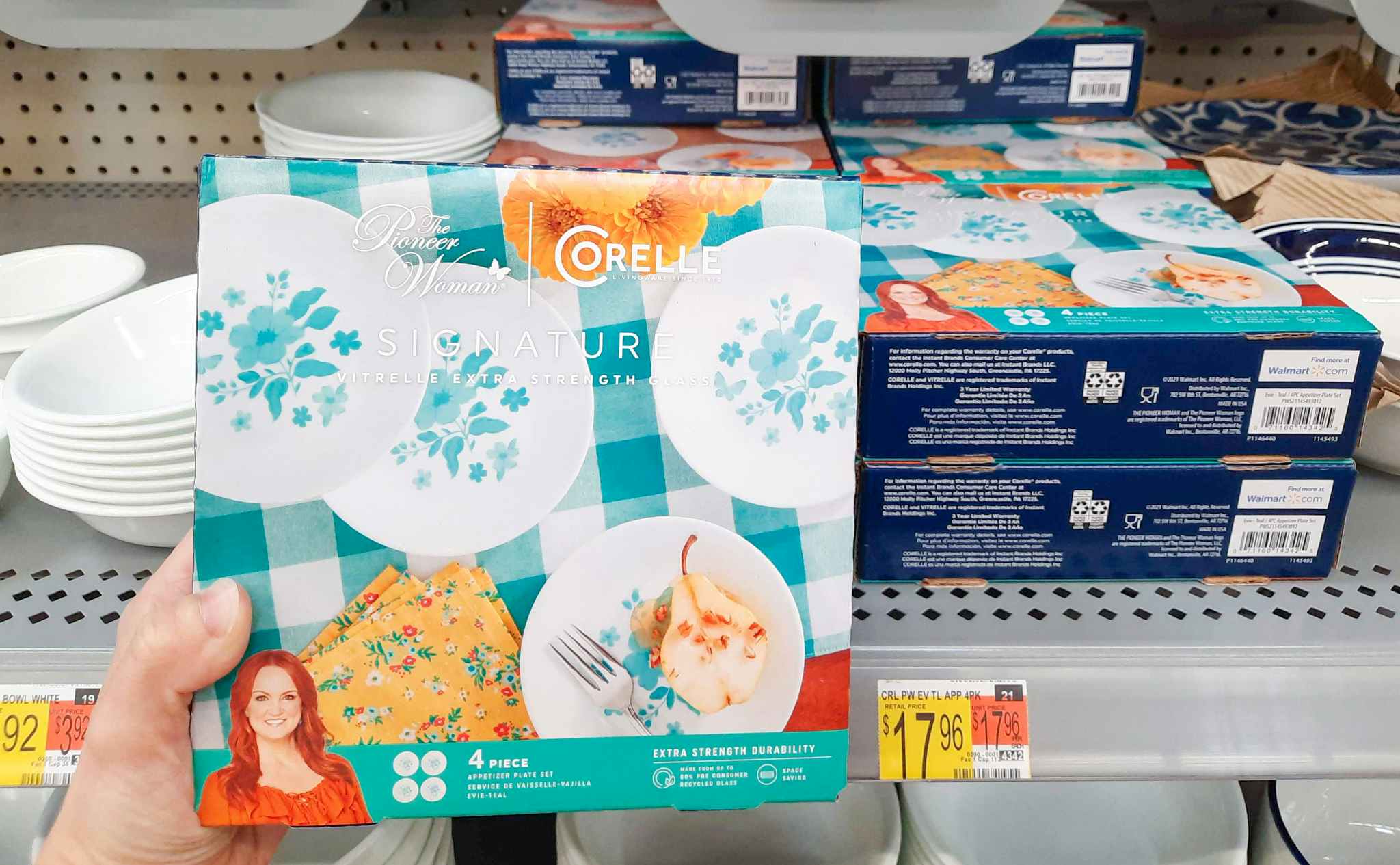 The Pioneer Woman by Corelle 4-Piece Appetizer Plate Set held in front of display at Walmart. Price tag indicates that the price is $17.96.