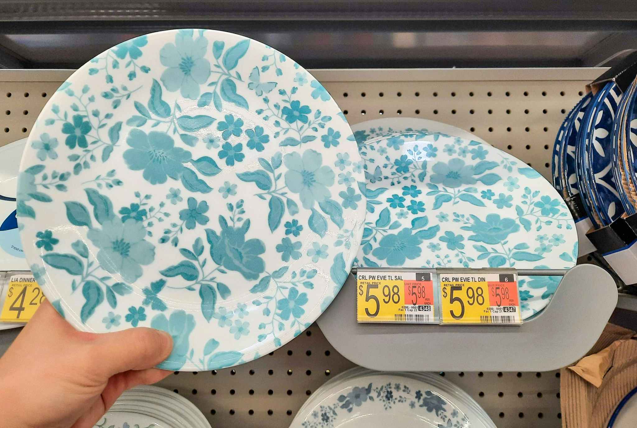 The Pioneer Woman by Corelle salad plate held in front of product display at Walmart. Price tag indicates that price is $5.98.