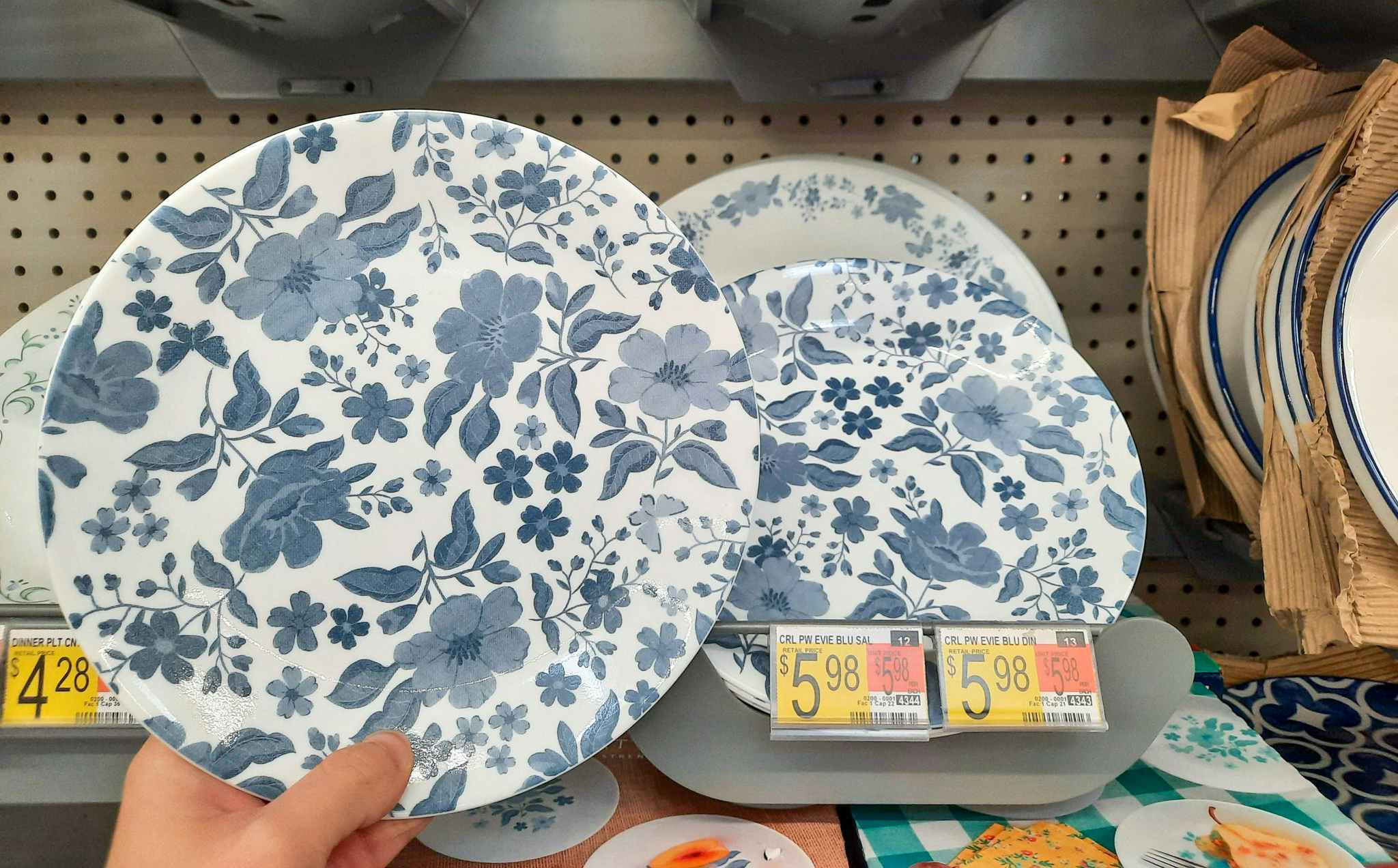 The Pioneer Woman by Corelle salad plate held in front of product display at Walmart. Price tag indicates that price is $5.98.
