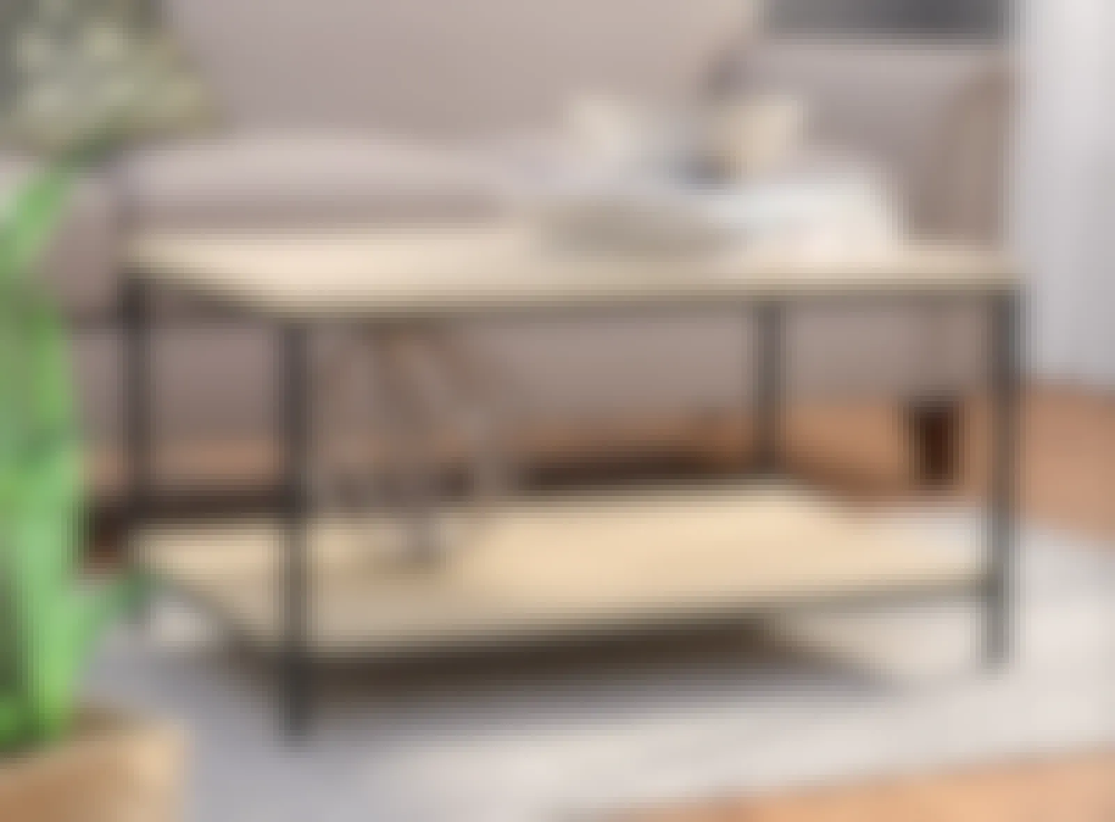 A screenshot of a Hanni 4 legs coffee table with storage set up in a living room from the Wayfair website.