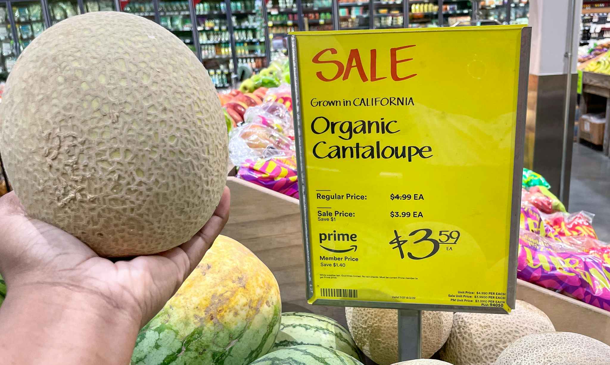 hand held cantaloupe near sales sign