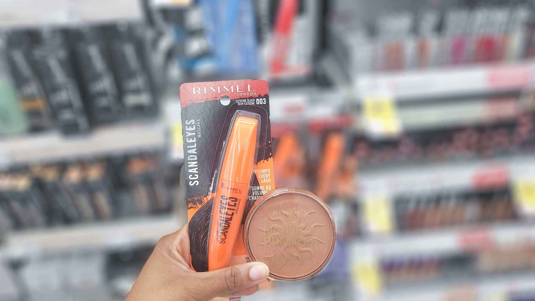 hand holding rimmel mascara and bronzer