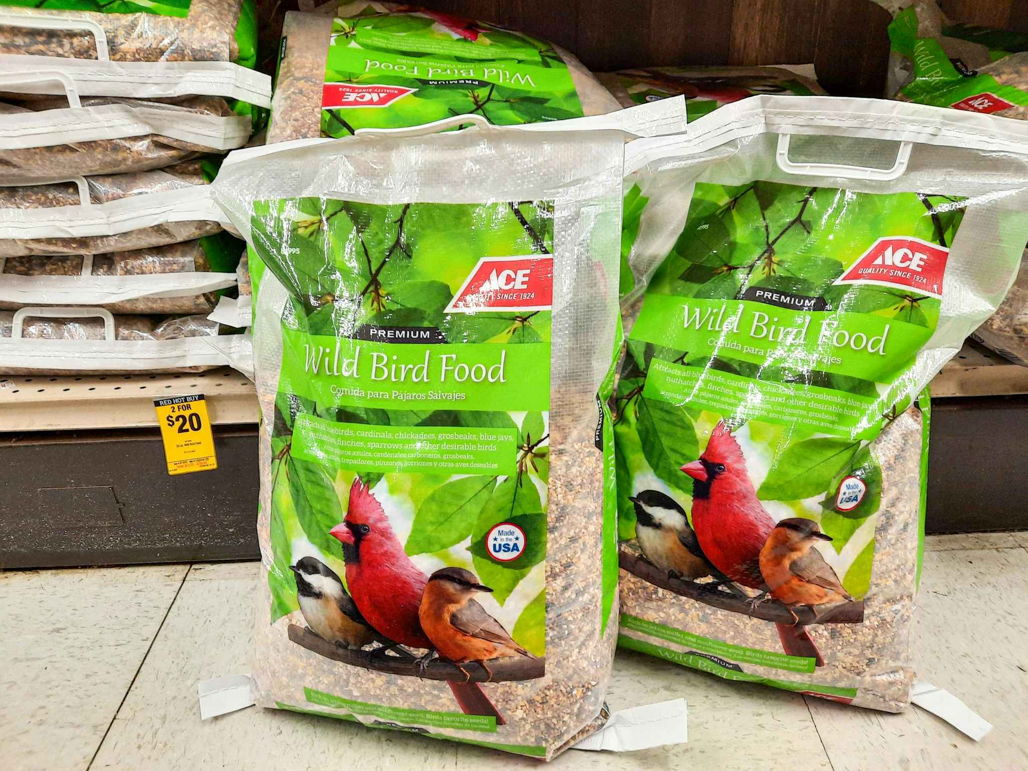 Two 20-pound bags of Ace Hardware brand wild bird food in front of shelf. Sale tag hanging from the shelf reads 2 for $20.