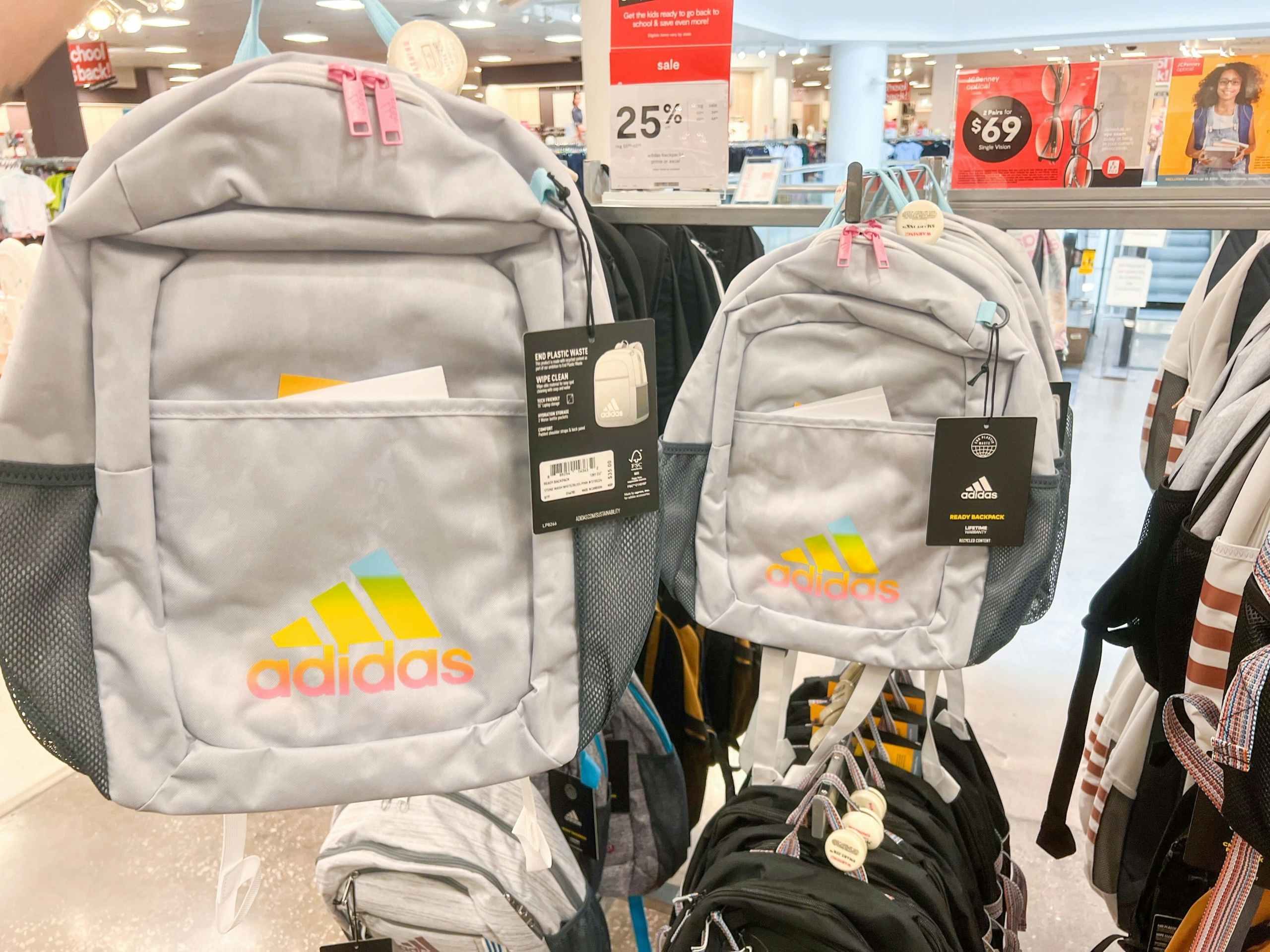 two grey backpacks with rainbow adidas logo