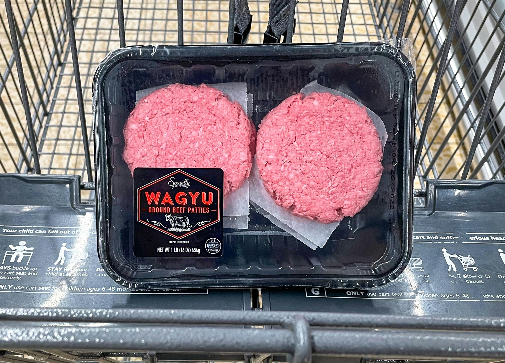 raw packaged beef patties in a cart at aldi