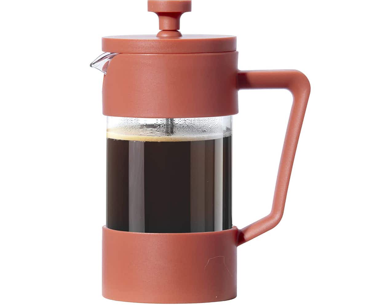 A brick red coffee press on a white background
