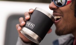 A person drinking out of a black tumbler