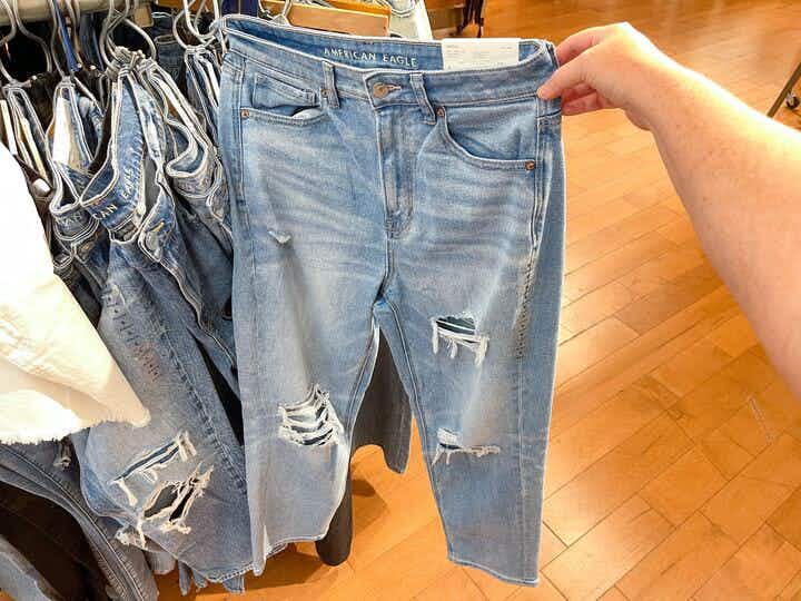 someone holding up a pair of jeans