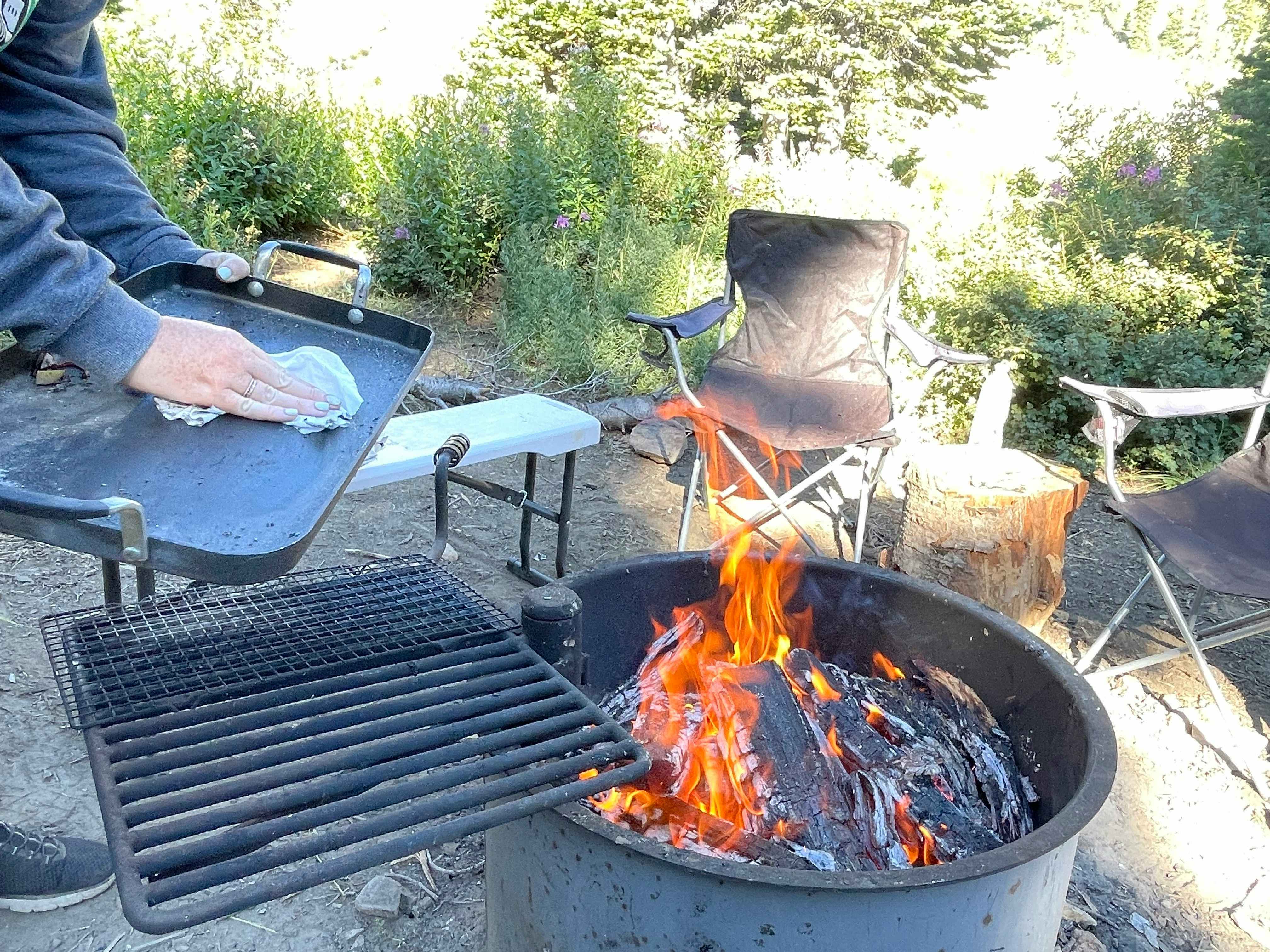 baby wipes at a campsite being used to wipe a flat top near fire