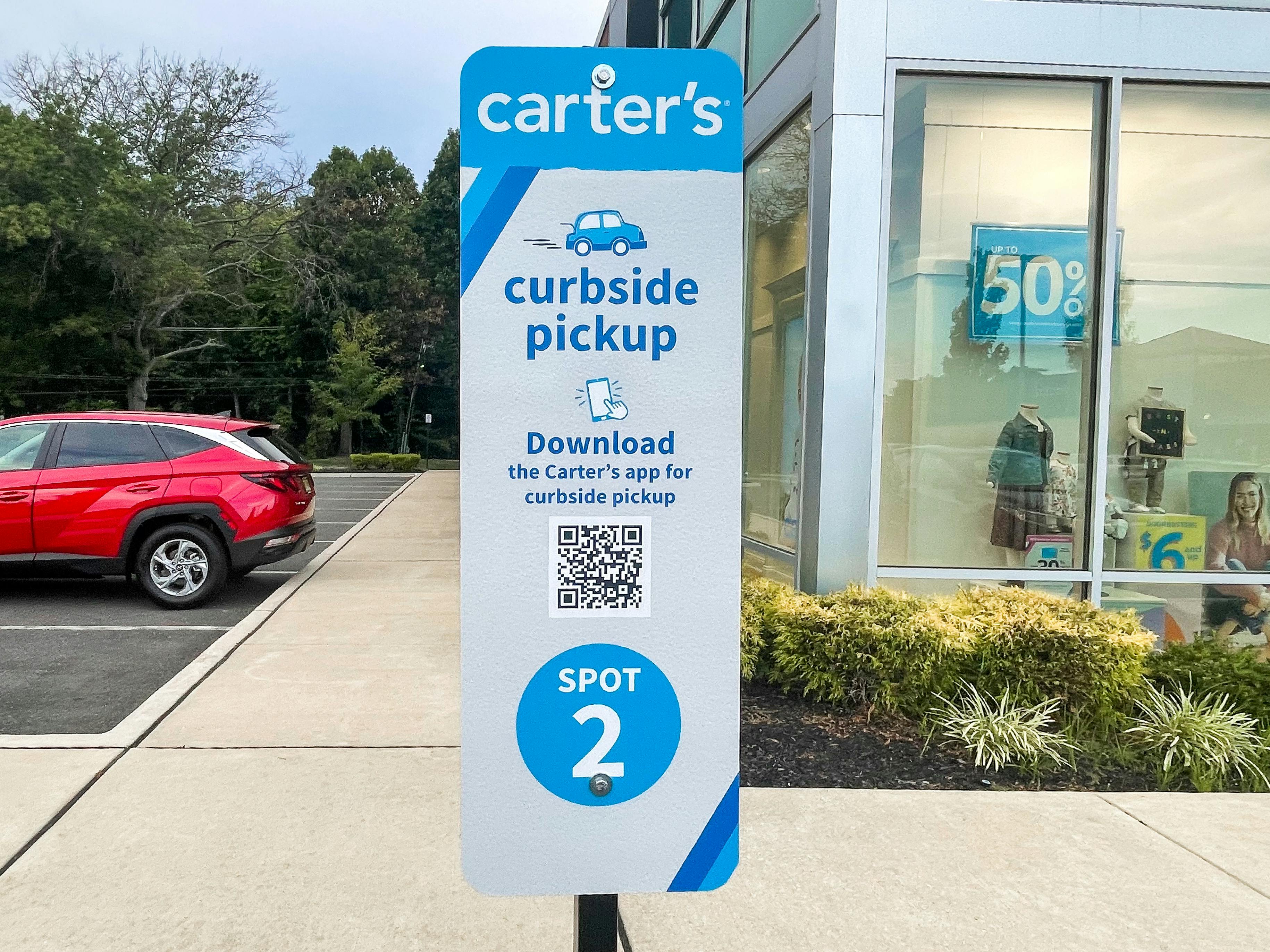 A Carter's online order curbside pickup sign outside of the store.