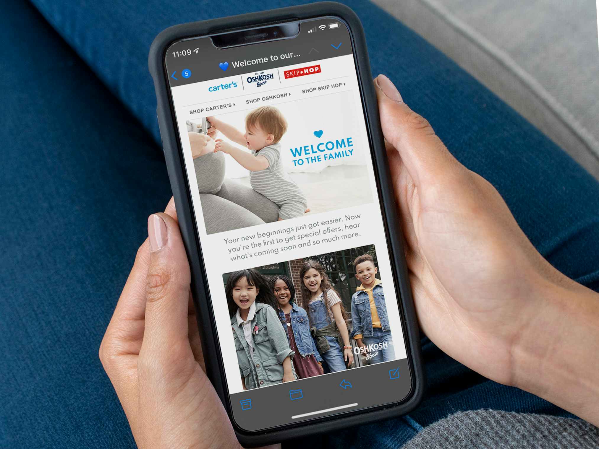 A person holding an iPhone displaying the Carter's "Welcome to the Family" email.