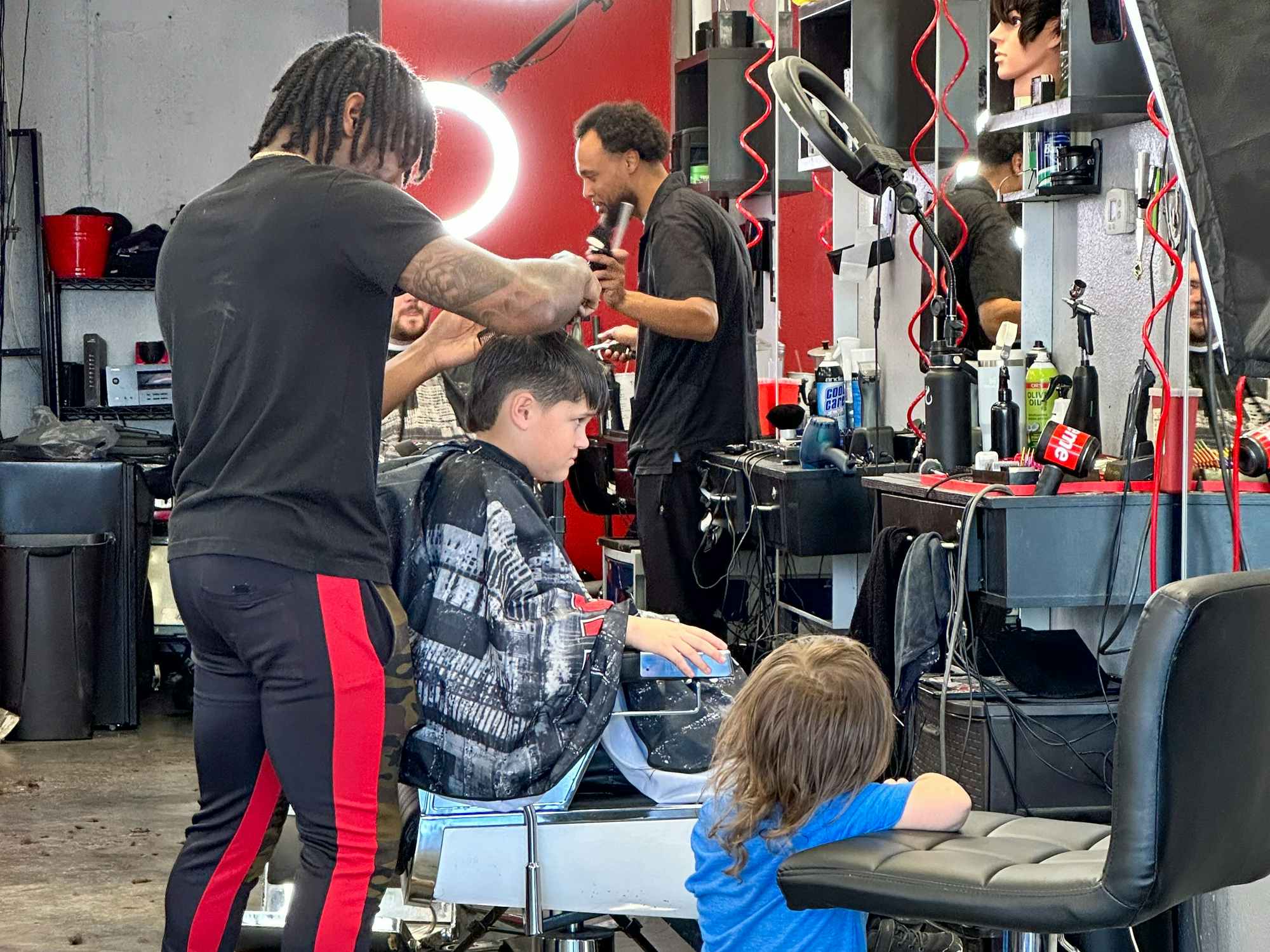 A young boy getting his hair cut at a barber shop