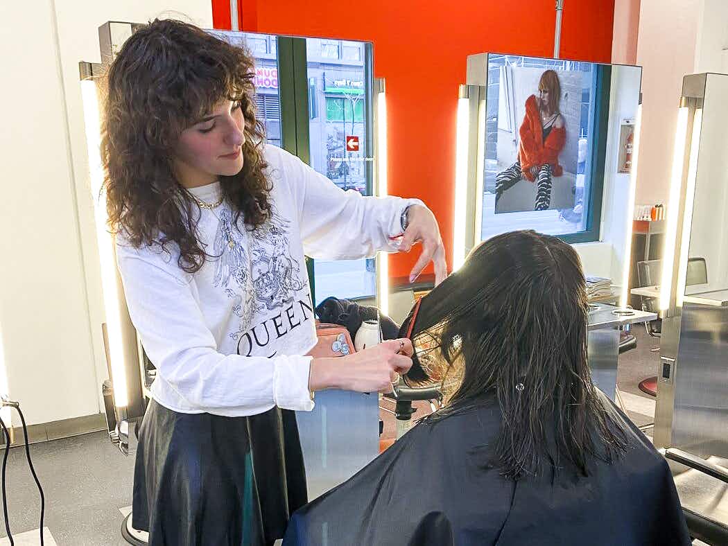 An Arrojo Cosmetology student cutting a client's hair