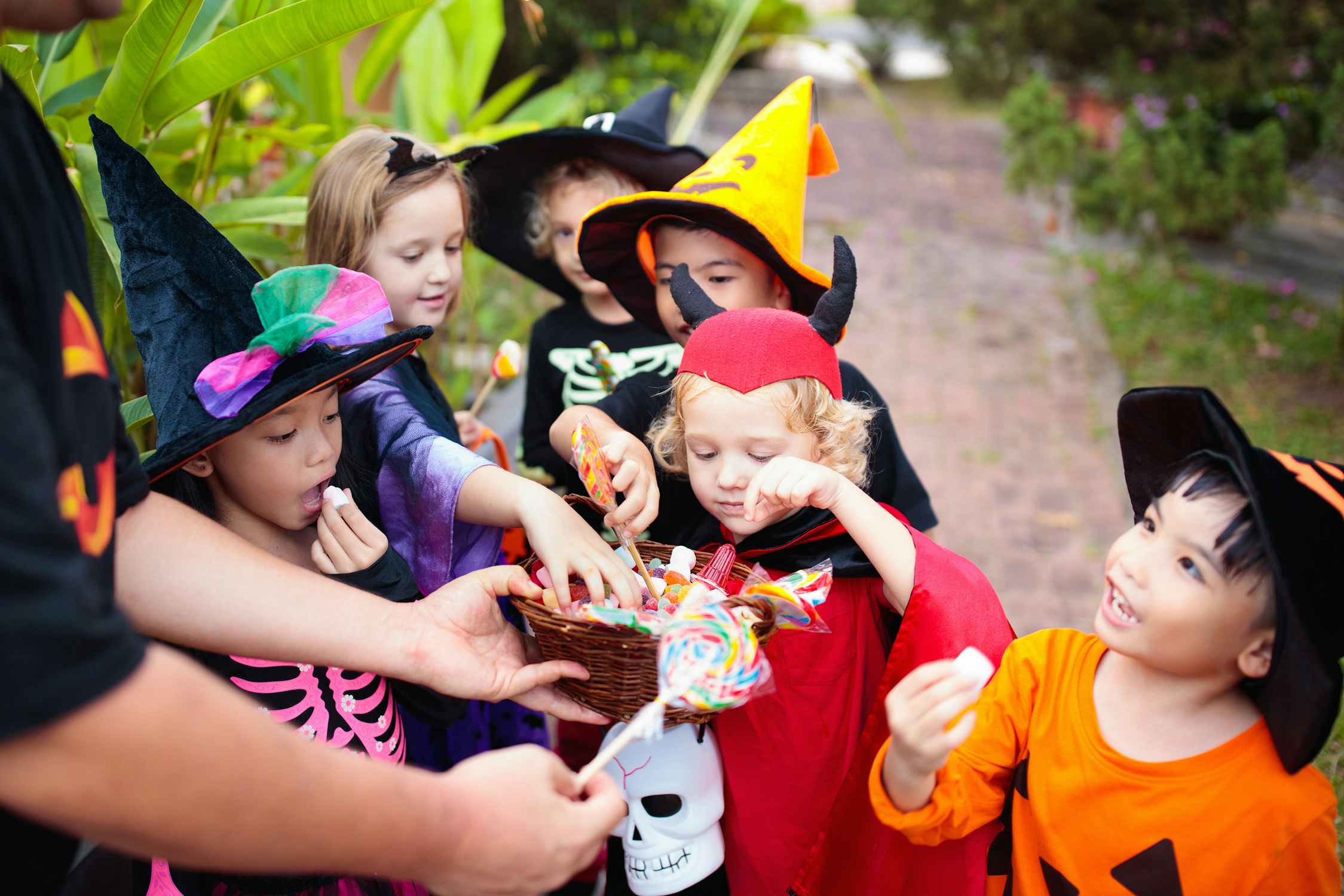 children in Halloween costumes picking candy and trick-or-treating