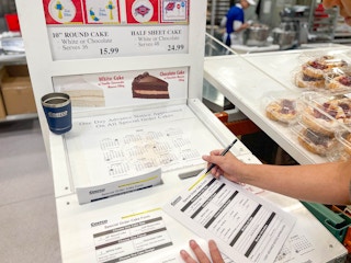 person filling out costco cake order sheet