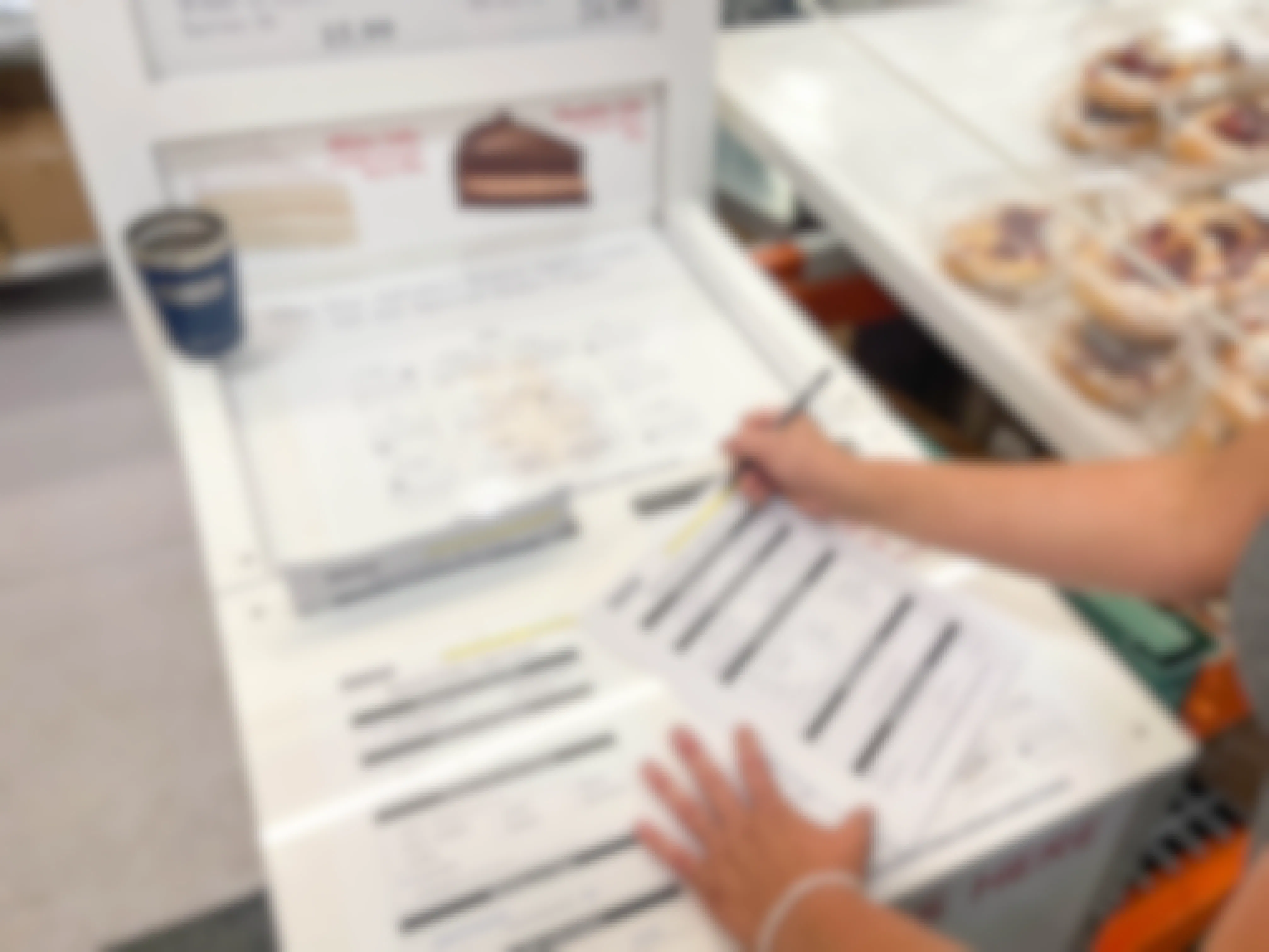 person filling out costco cake order sheet