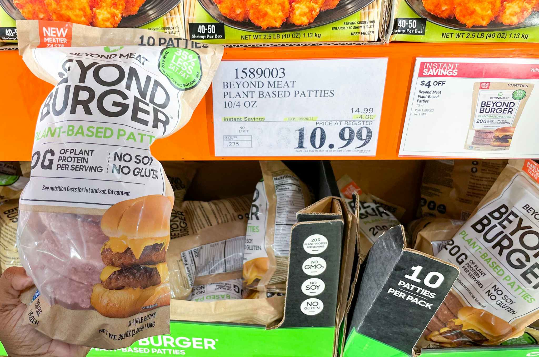 plant based burger patties hand held near sale sign at costco