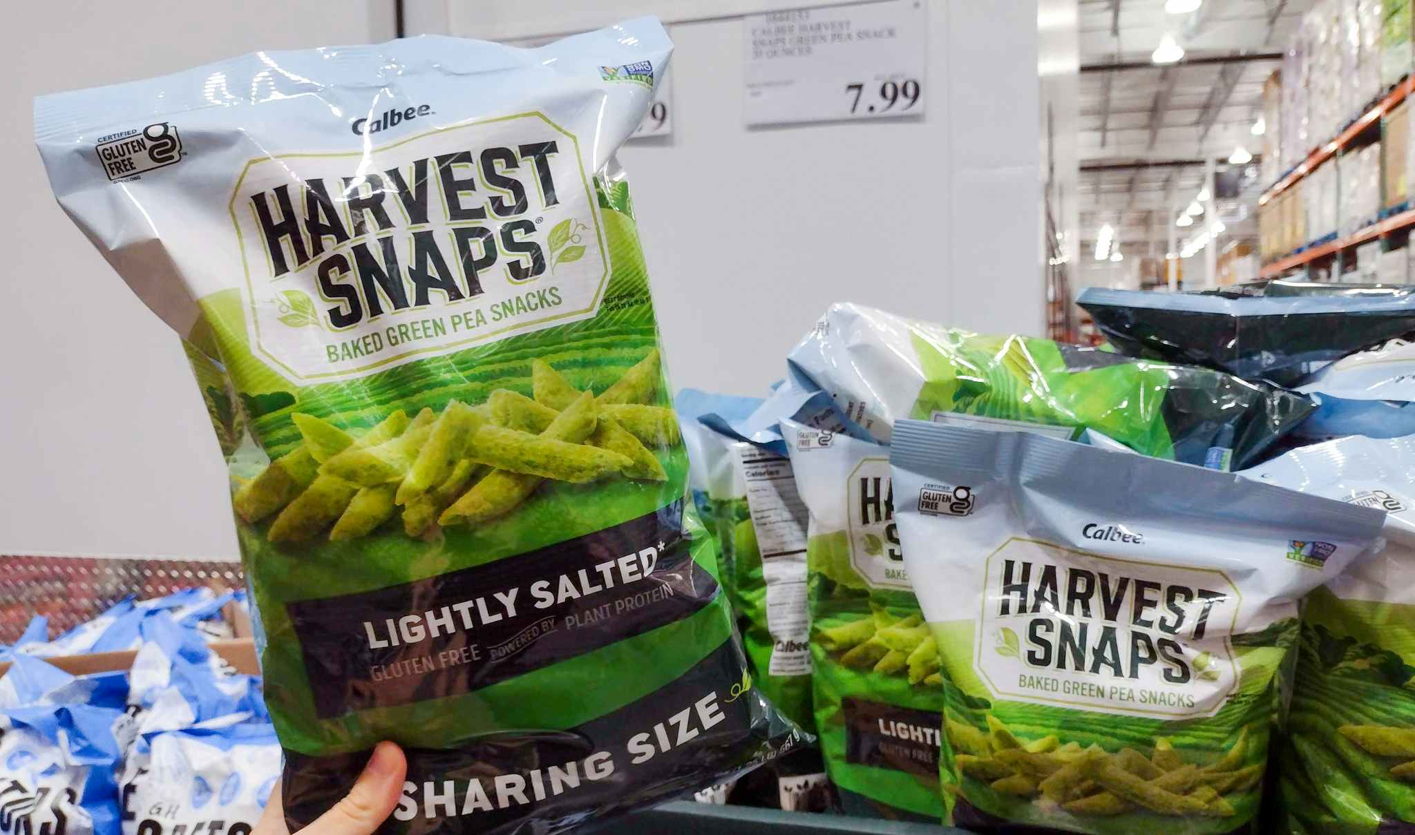 veggie snacks held in hand near sales sign