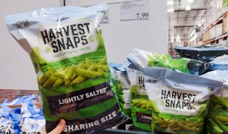 veggie snacks held in hand near sales sign