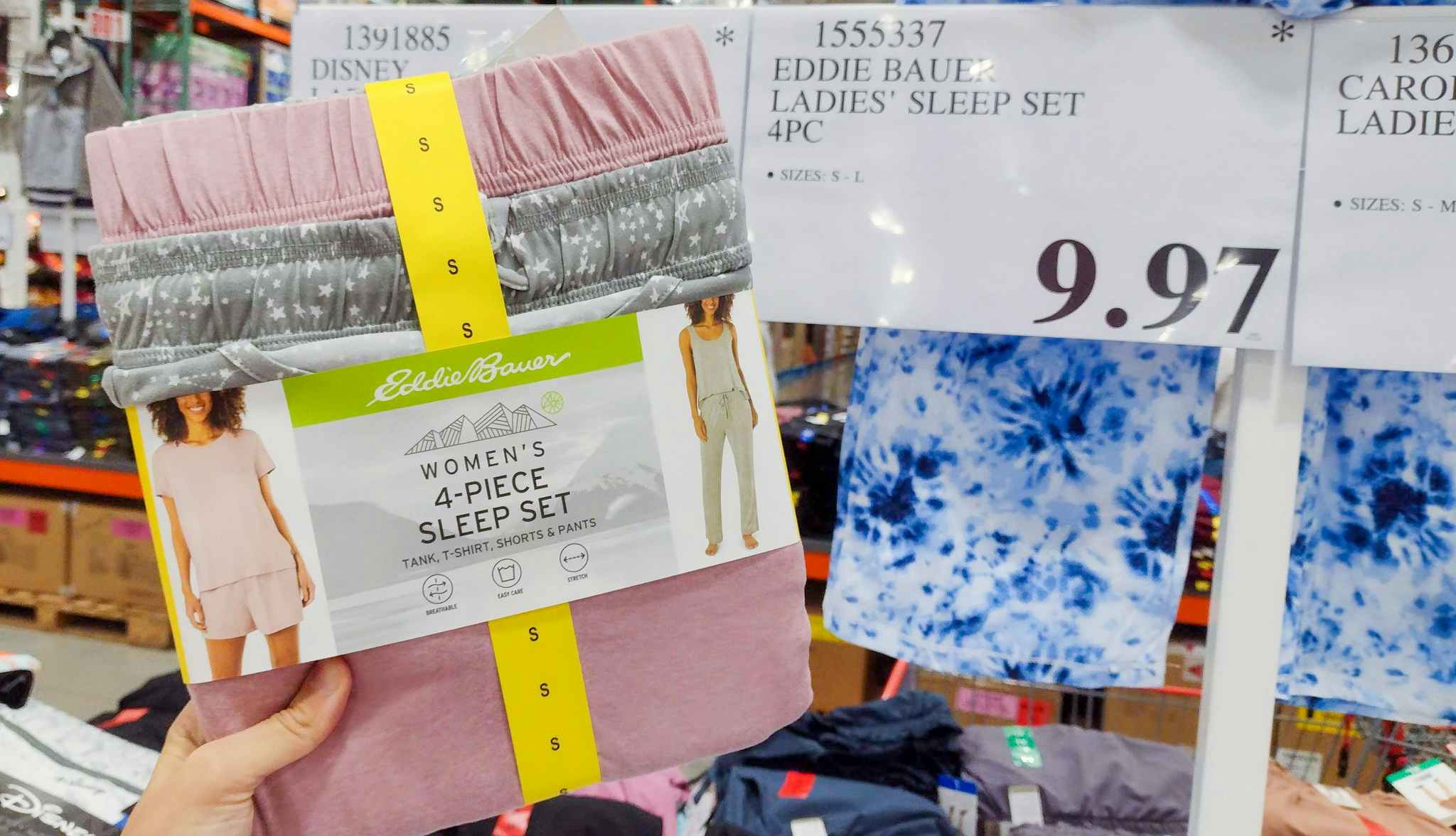 pajamas held in hand near sales sign at costco