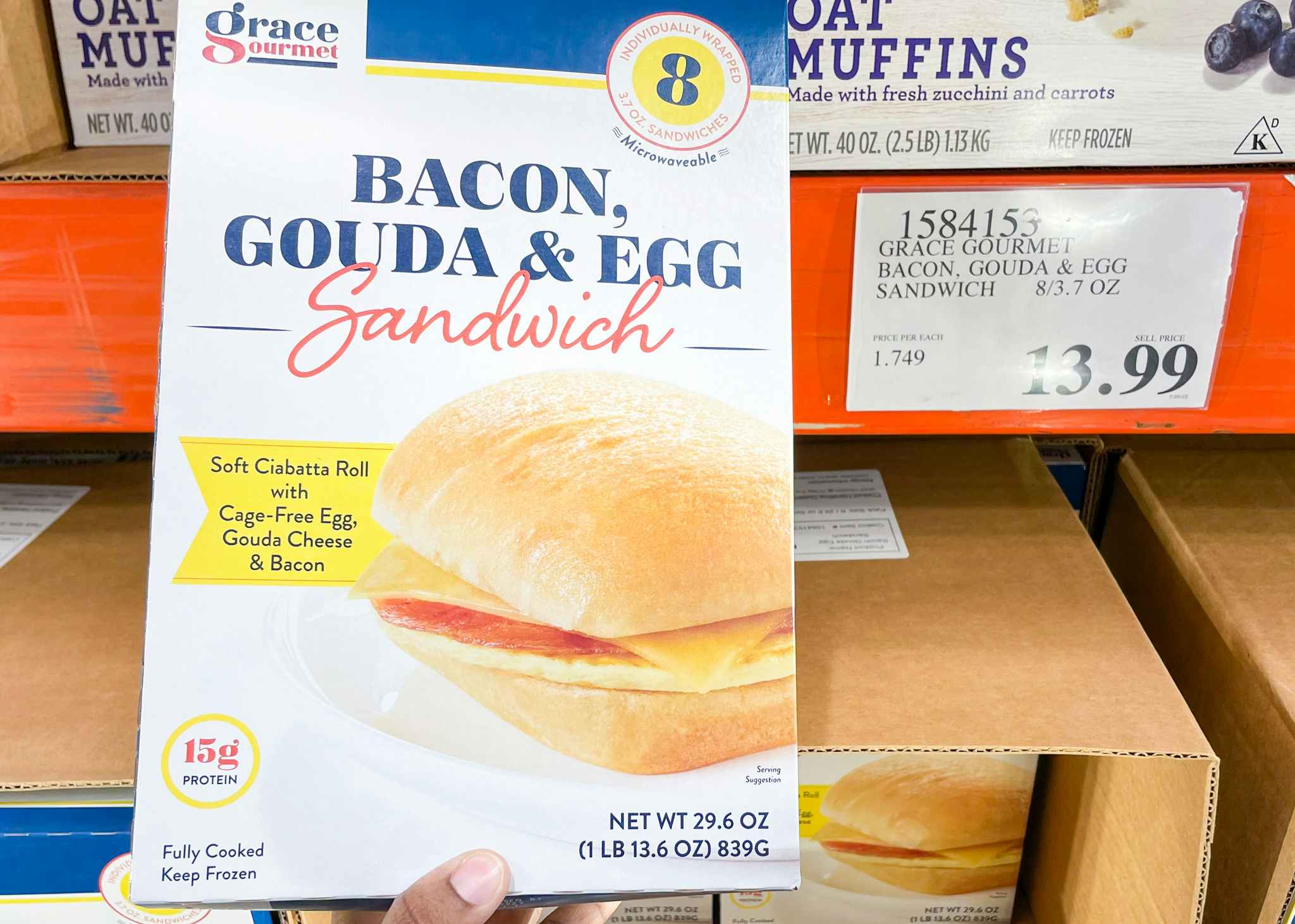 breakfast sandwiches in a box hand held near sale sign at costco