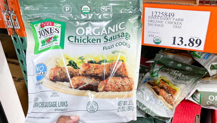 packaged organic chicken sausage hand held near sale sign
