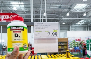 vitamin d hand held near sale sign at costco