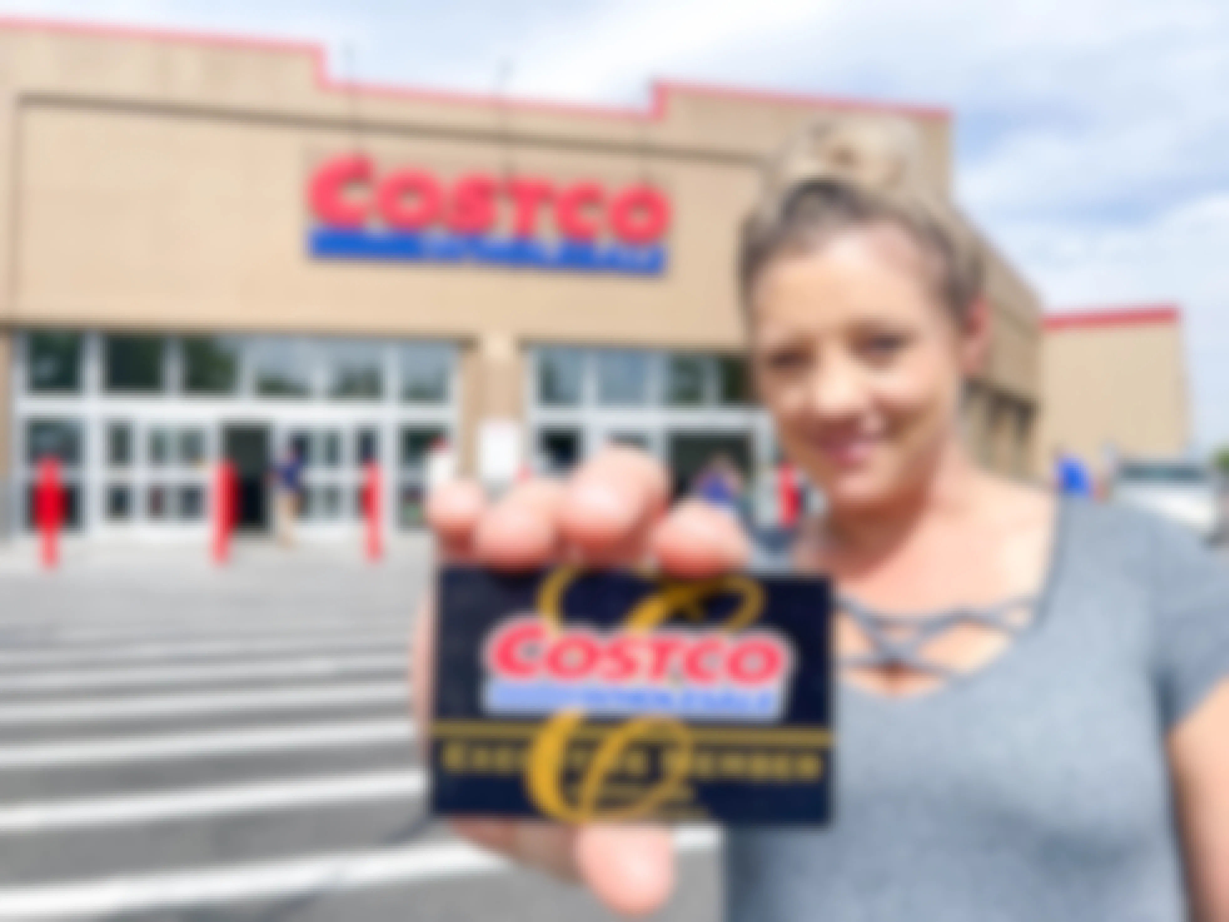 a woman holding a costco membership card in front of costco