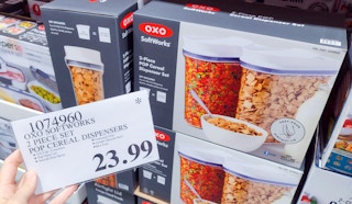 cereal dispenser on a shelf with sales sign held in hand