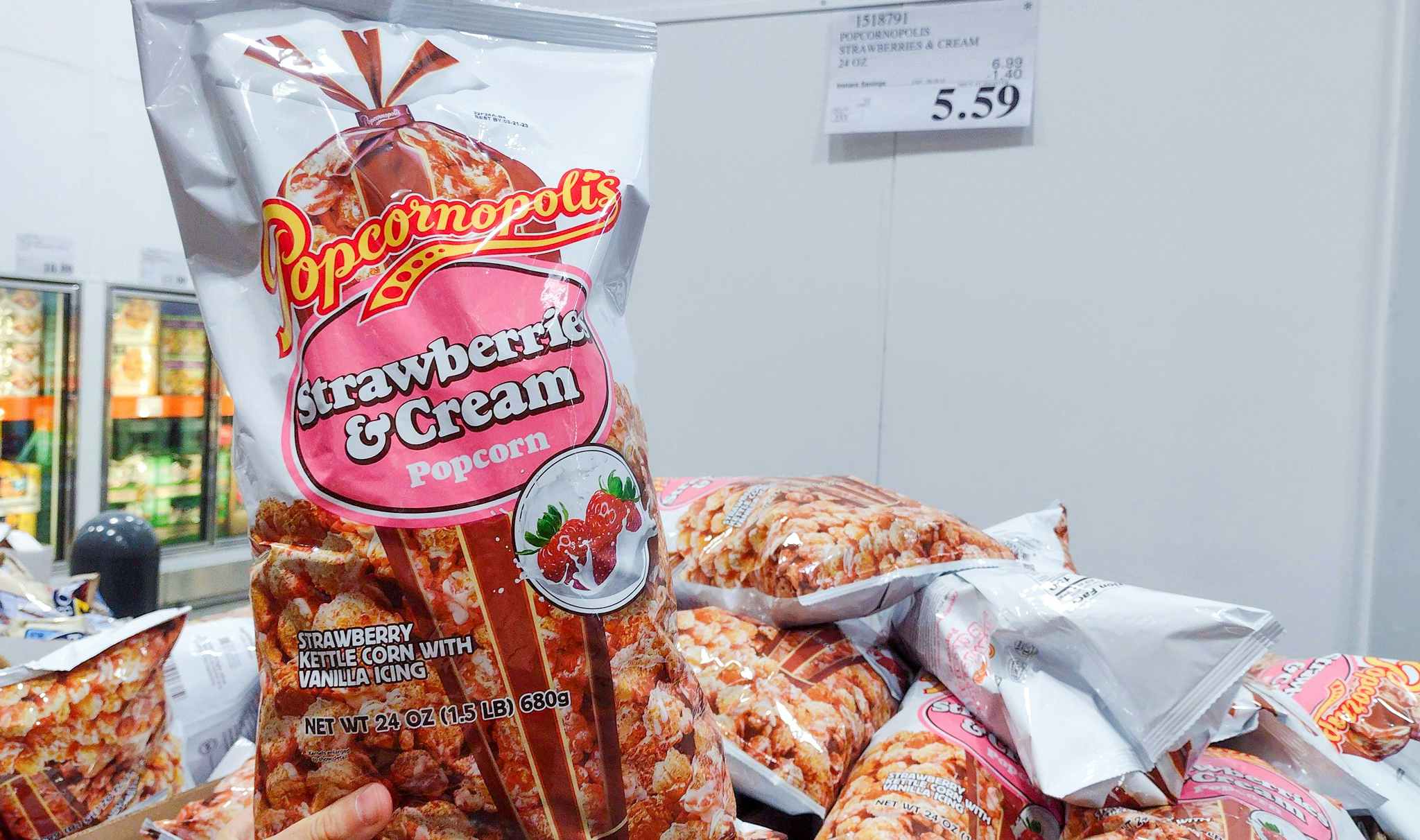 popcorn bag held in hand near sales sign