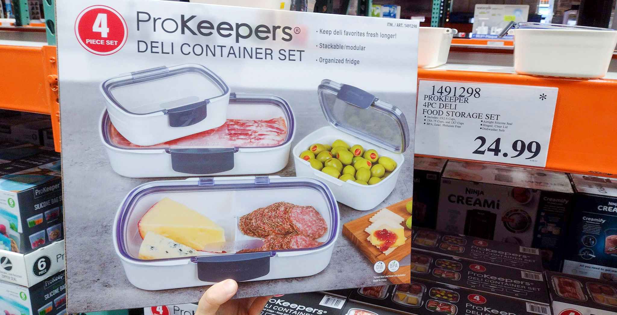 deli container set in a box held in hand near sales sign at costco
