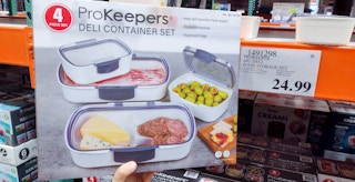 deli container set in a box held in hand near sales sign at costco