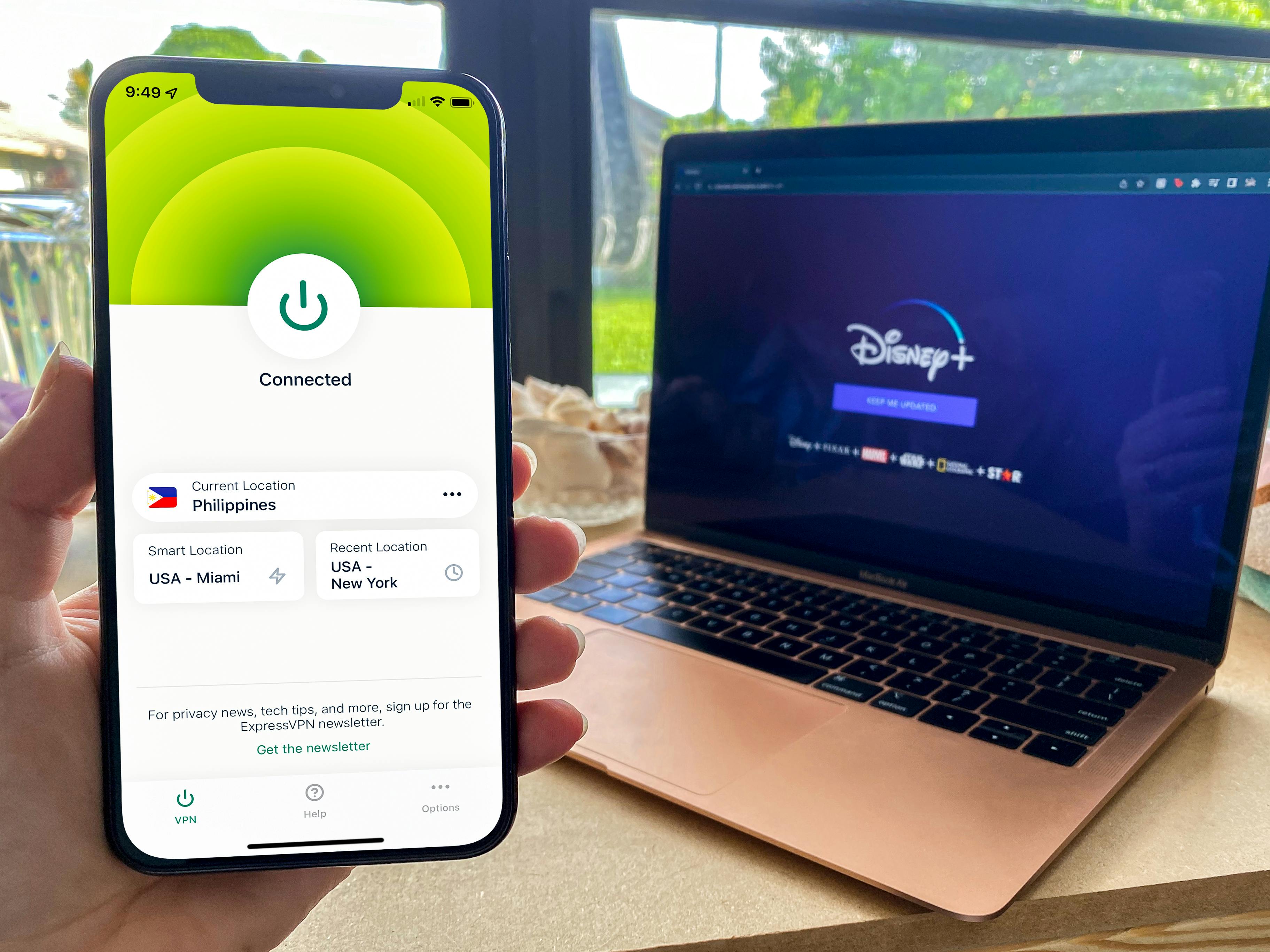 phone with VPN app and laptop showing Disney Plus in background