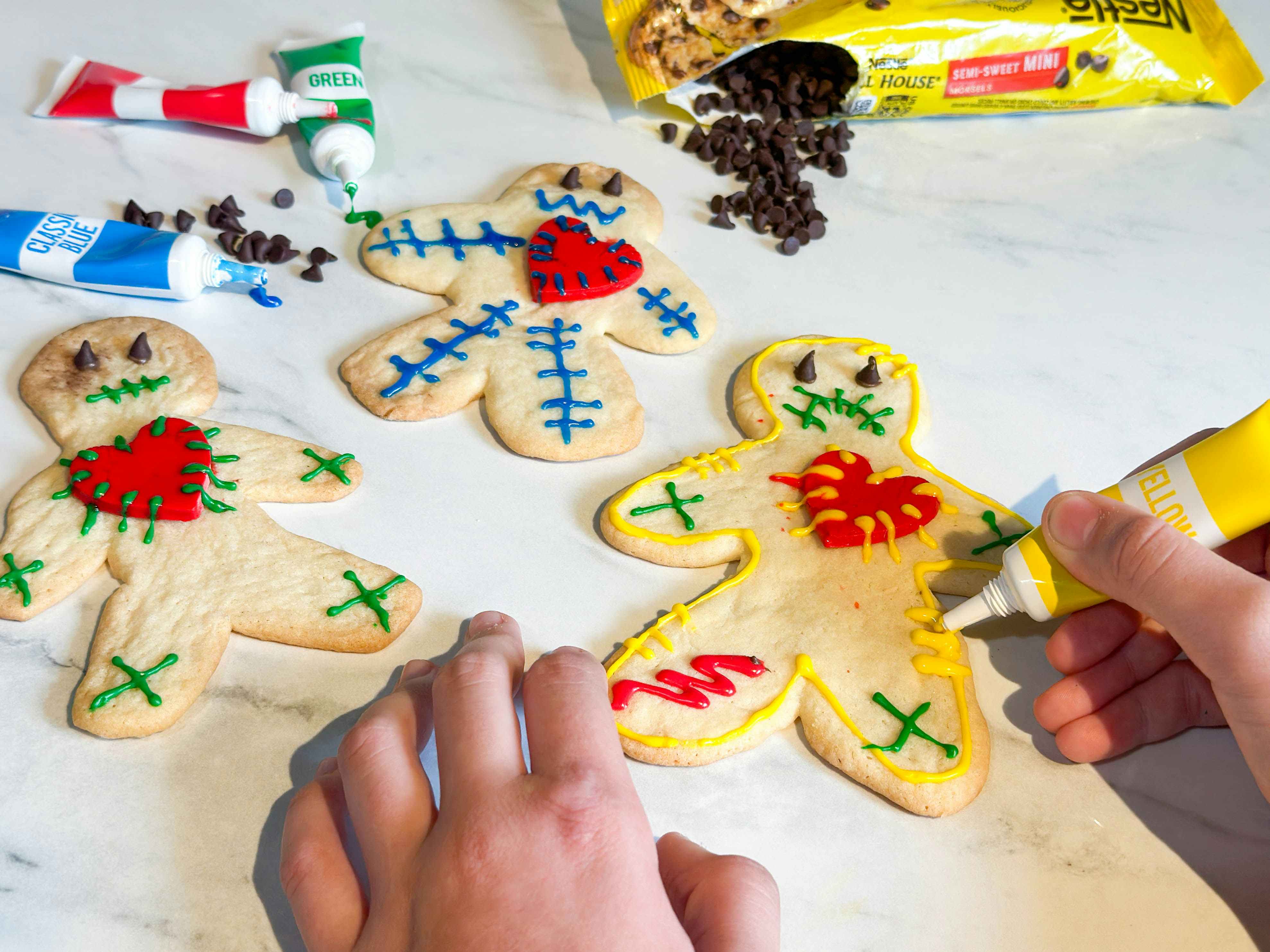 voodoo doll cookies being decorated on a countertop