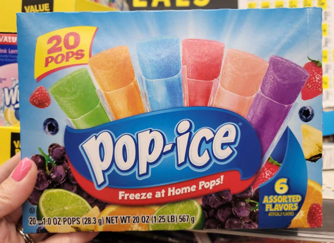 a person holding up pop ice in a store
