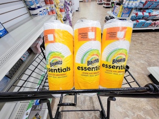 3 rolls of bounty essentials paper towels in a cart at dollar tree