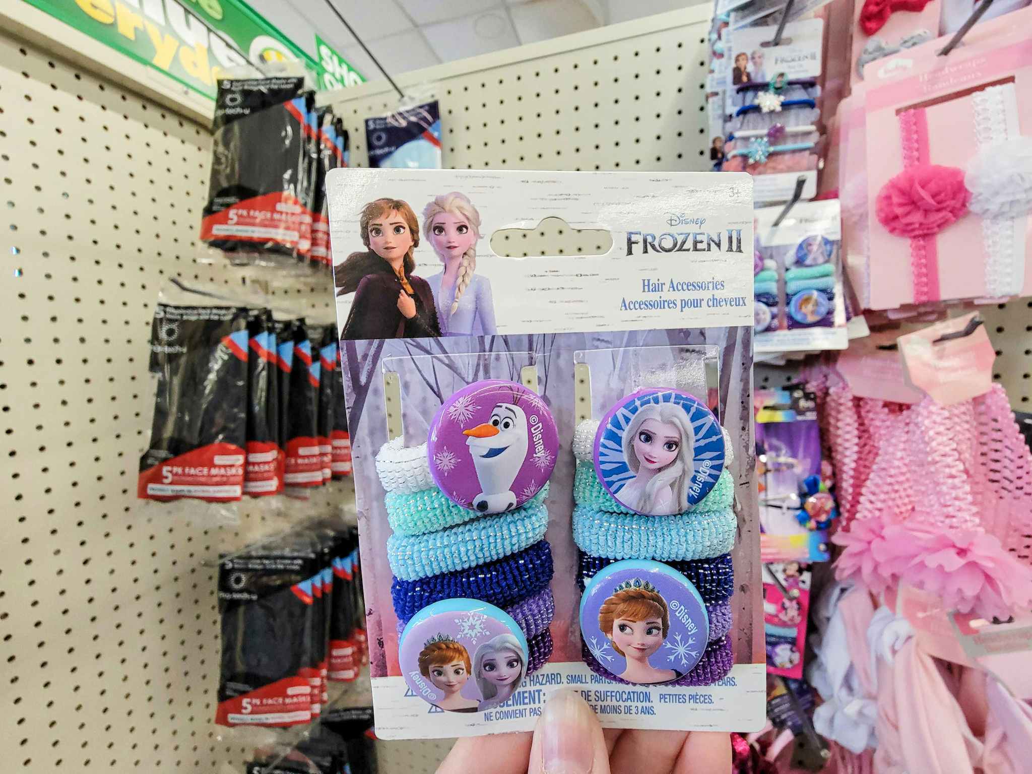 hand holding a pack of thick disney frozen hair ties featuring circle decals with characters