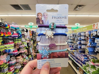 hand holding a pack of disney frozen hair ties with character decals on them