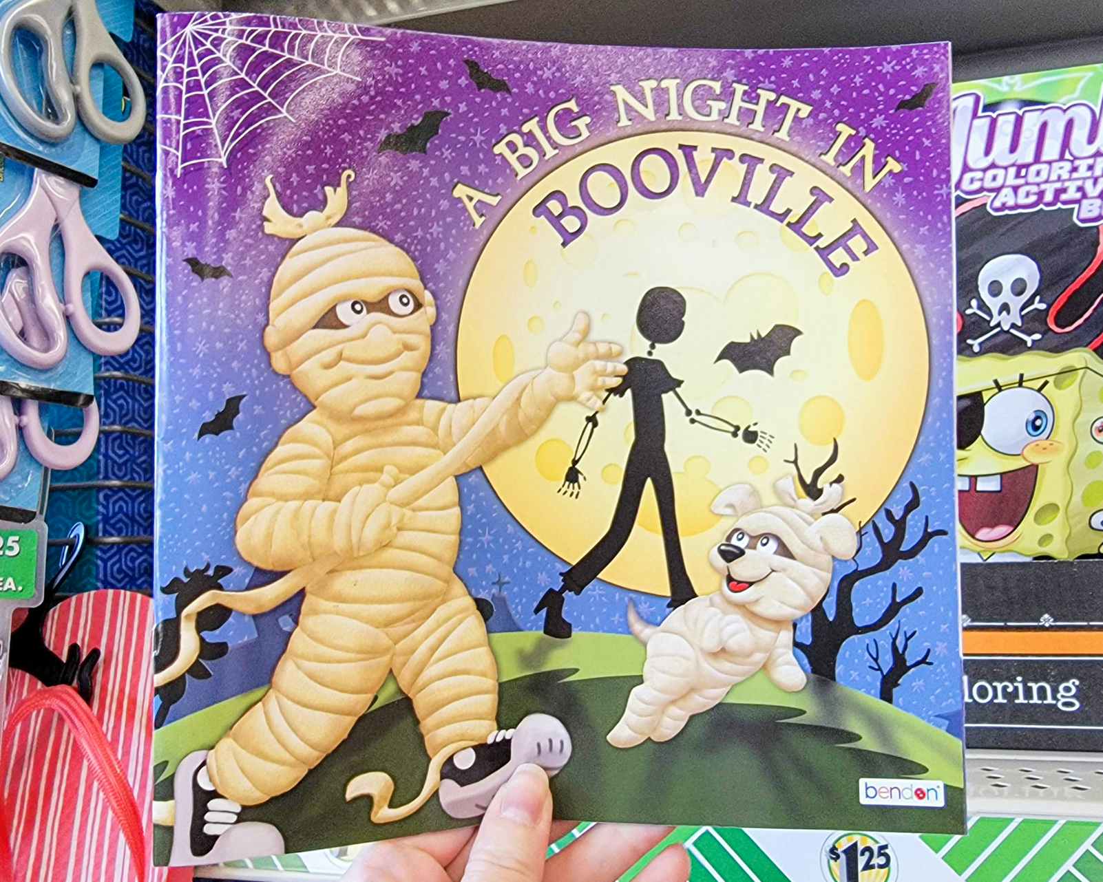hand holding a paperback kids book named a big night in booville