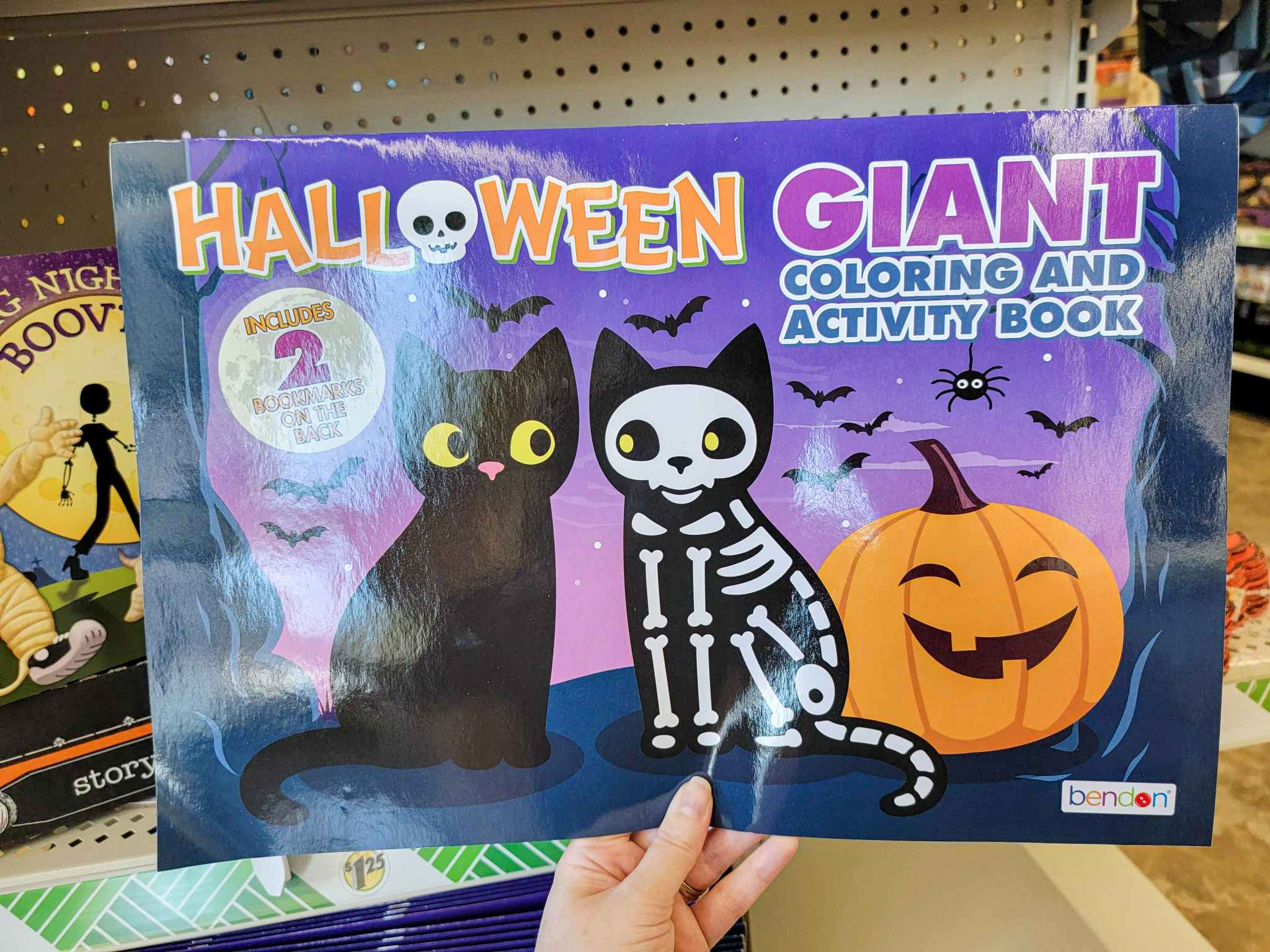 hand holding a giant halloween themed coloring and activity book