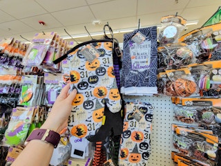 hand holding a halloween oven mitt by halloween towels