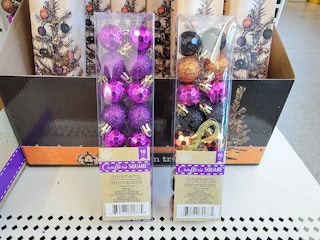 two small packs of purple, orange, and black ornaments for halloween trees