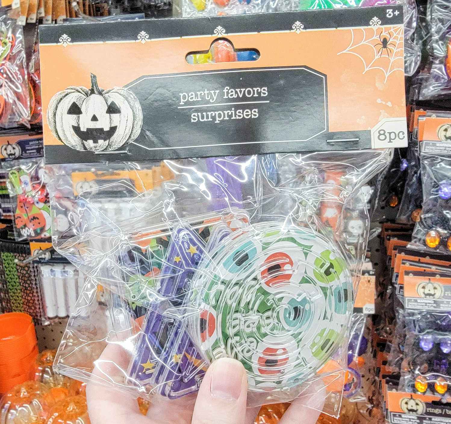 hand holding a pack of maze toys with halloween decoration