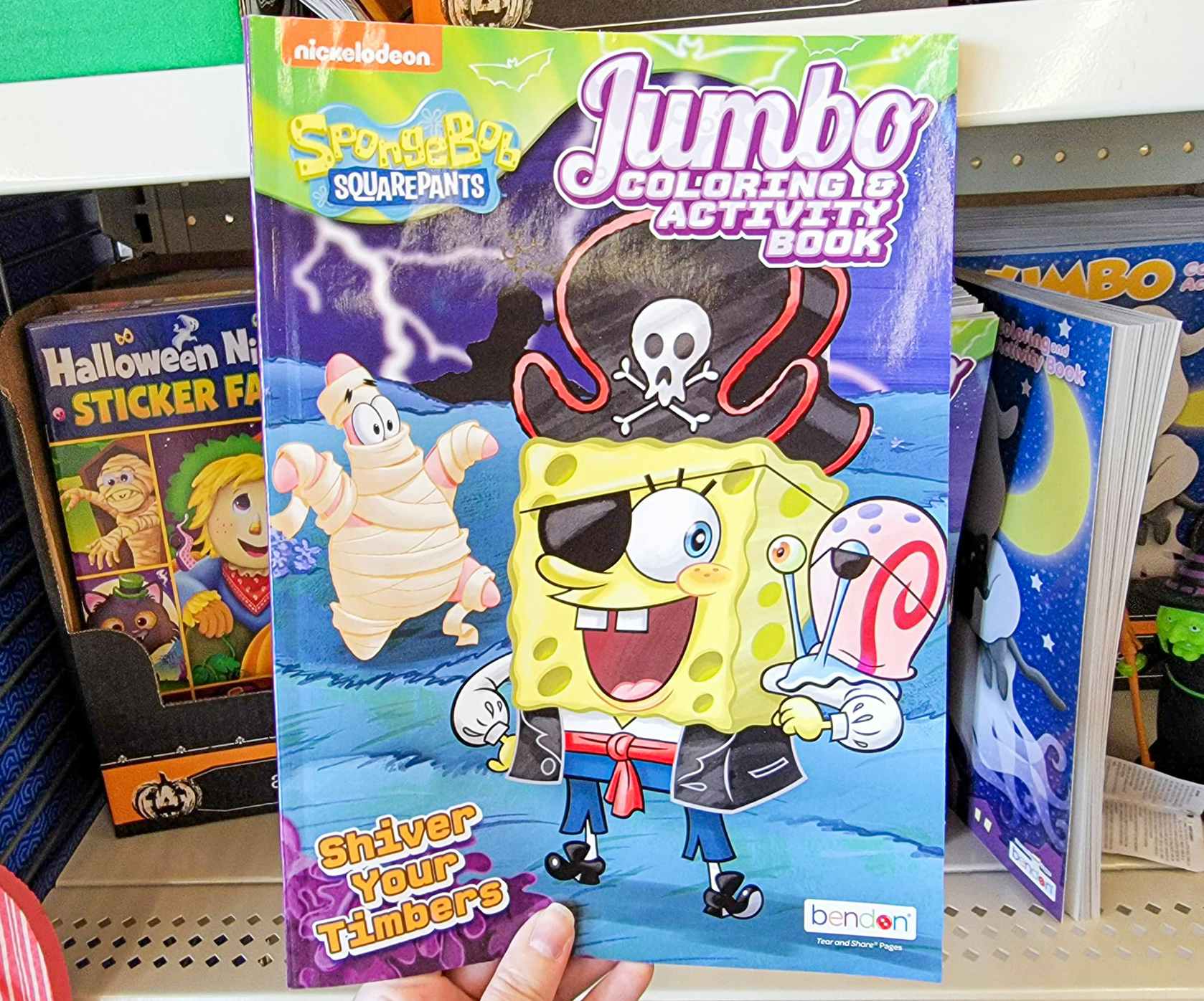 hand holding a spongebob kids halloween activity and coloring book