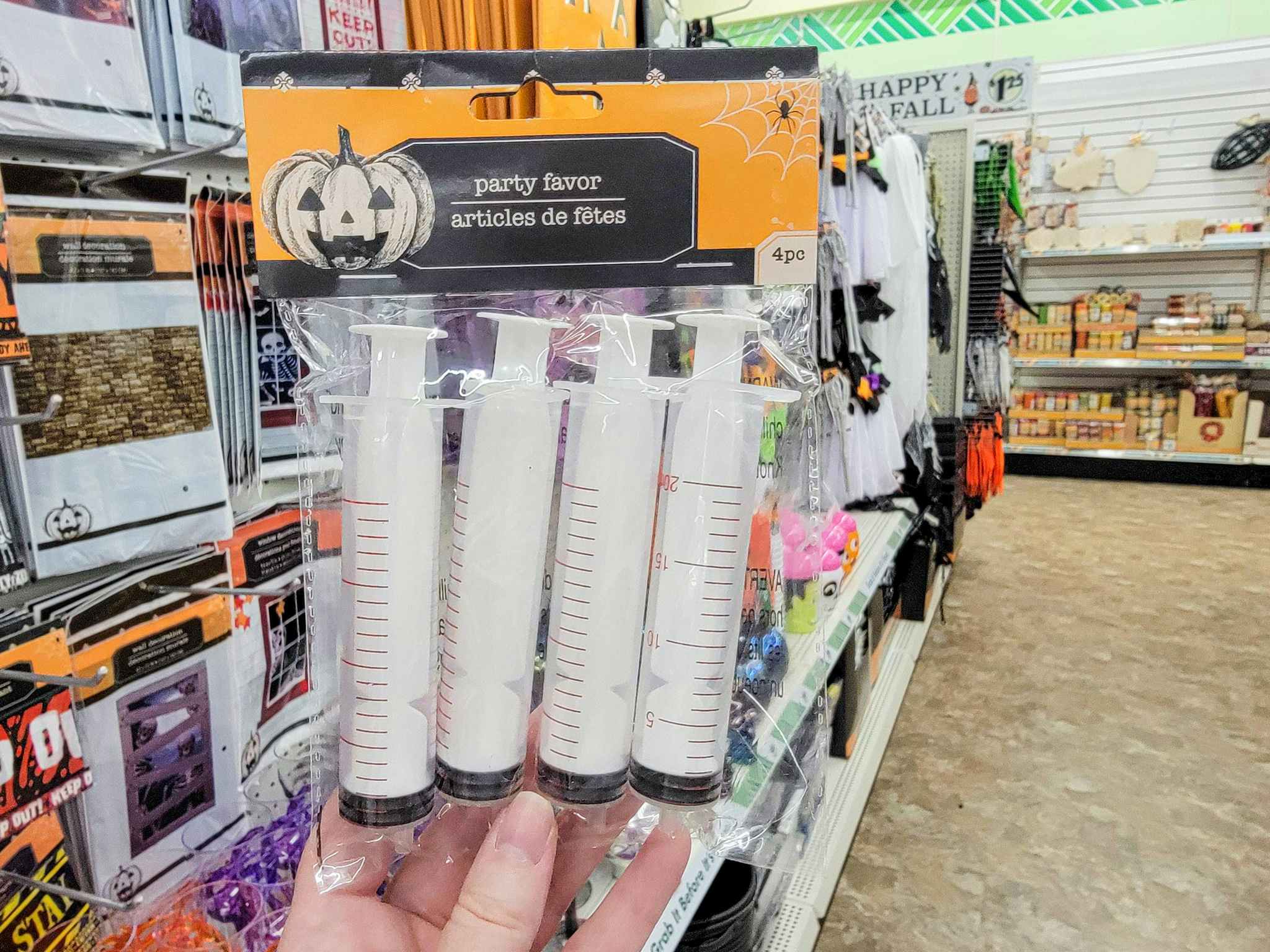 hand holding a pack of 4 halloween toy syringes