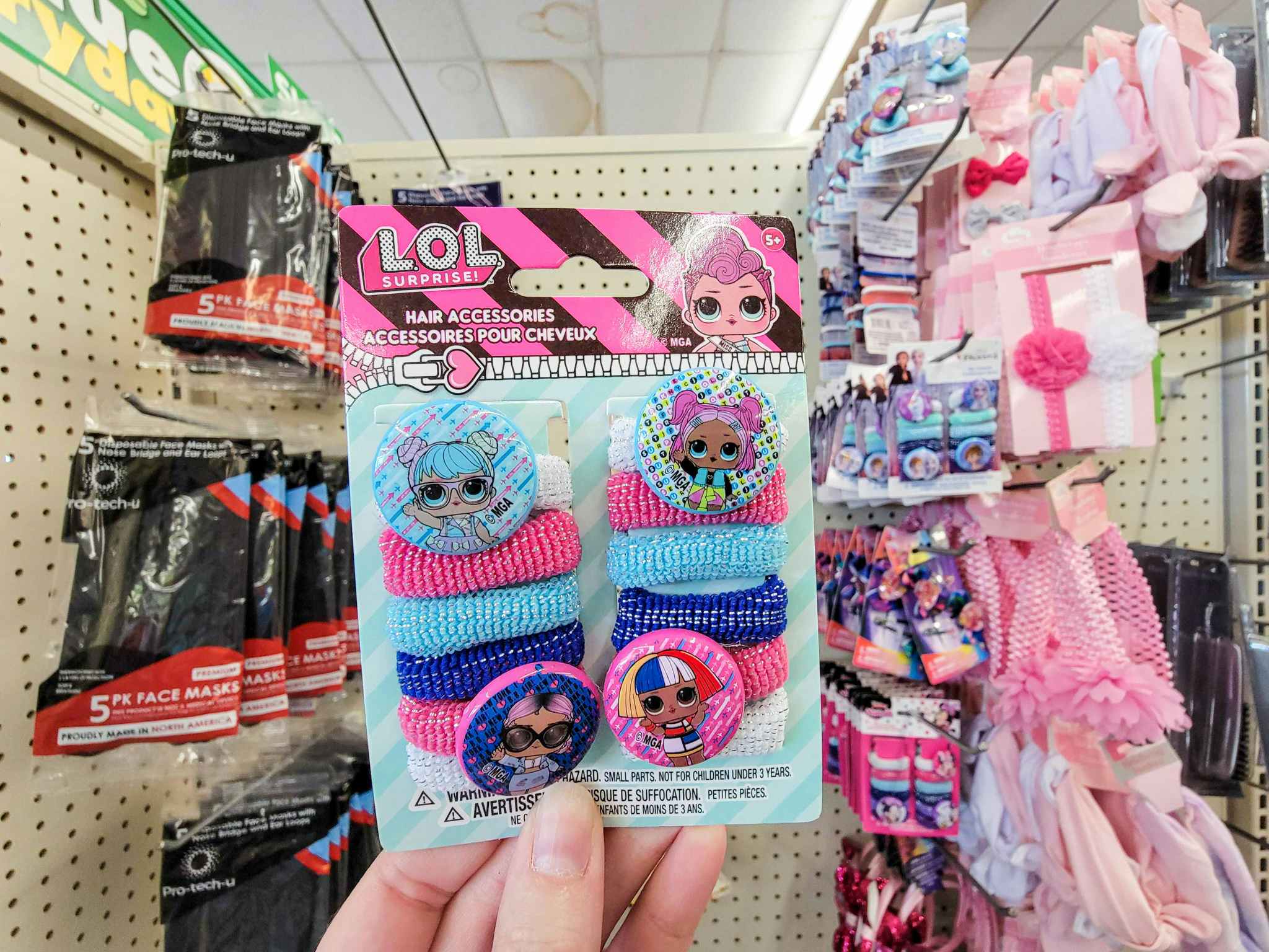 hand holding a pack of thick hair ties featuring lol surprise character decals