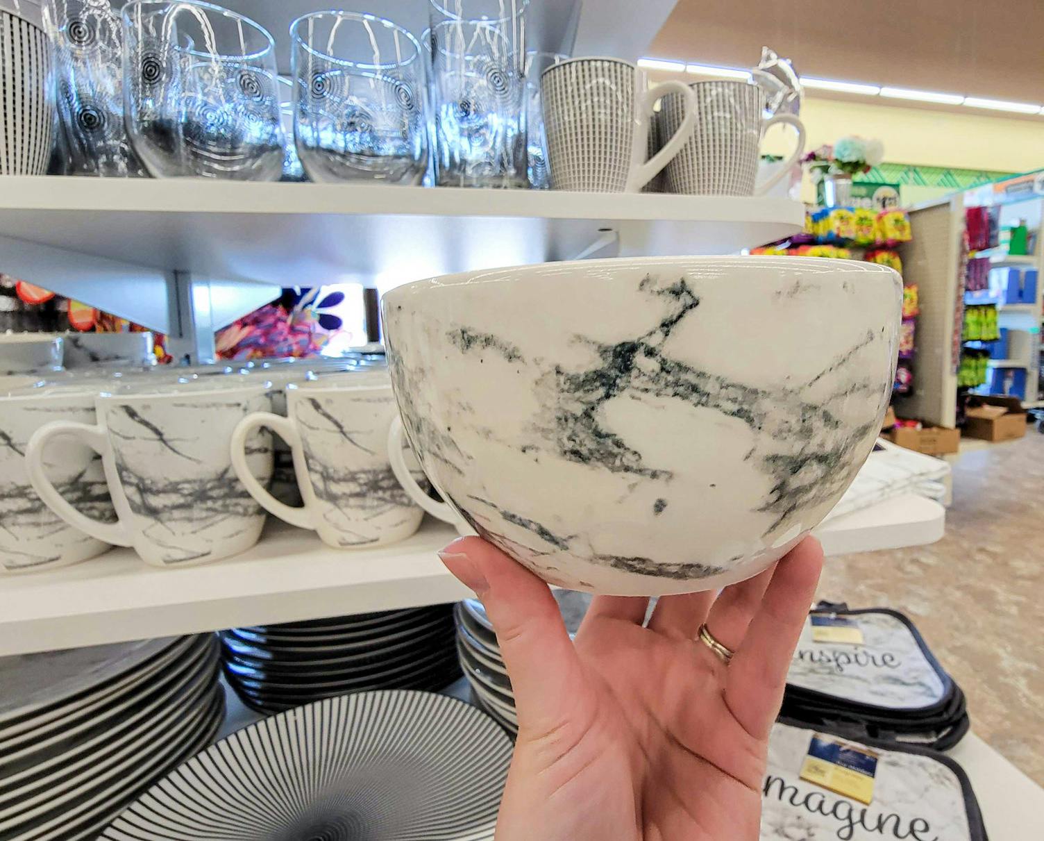 hand holding a white bowl marbled with grey
